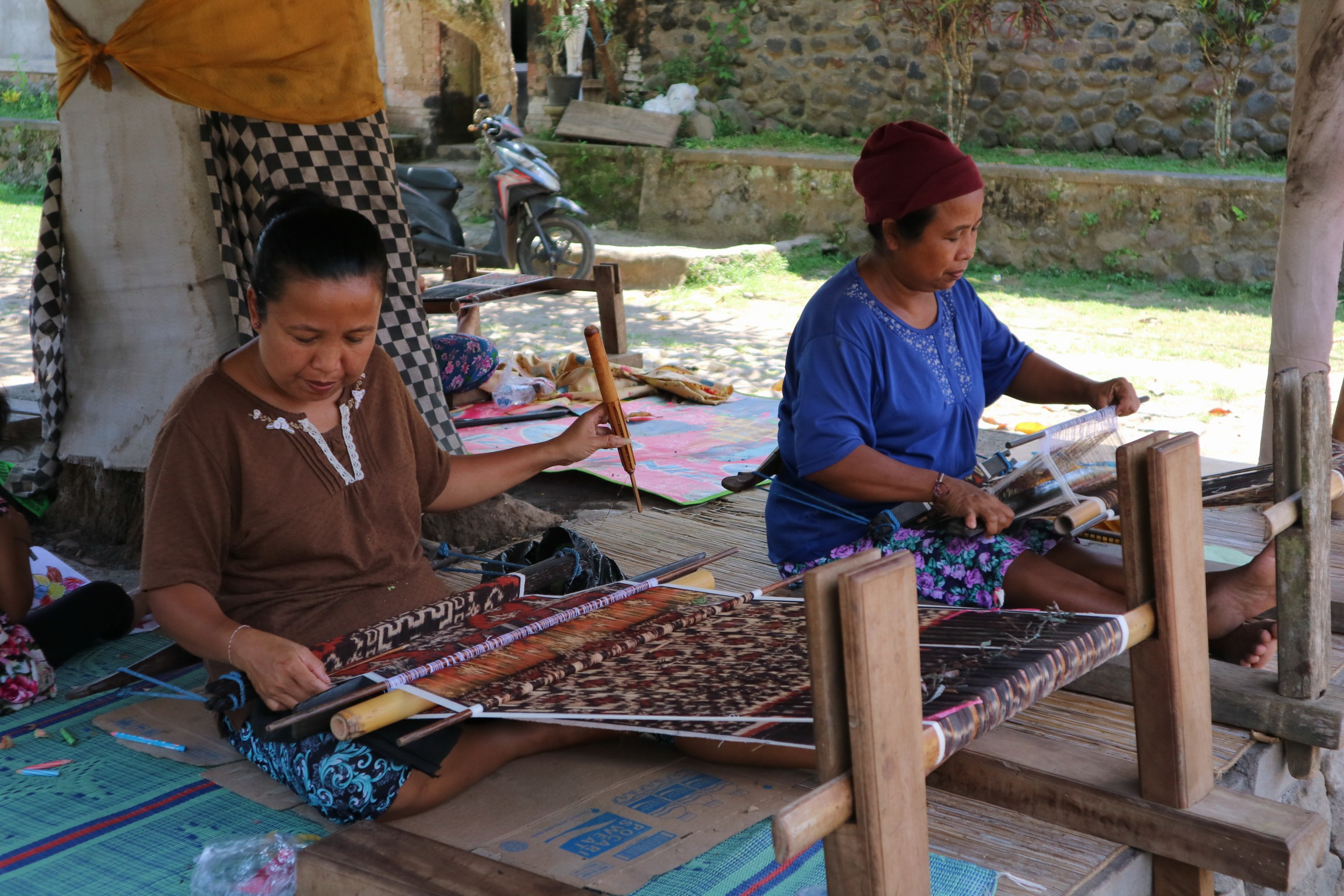 Meanwhile, traditional Balinese weaving takes place as artisans work on handwoven textiles using wooden looms, preserving local craftsmanship and cultural heritage.