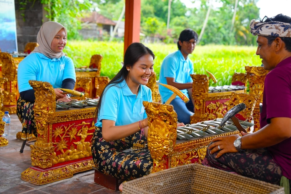 meanwhile, a Balinese gamelan lesson shows participants playing ornate red-and-gold instruments in an open pavilion overlooking rice fields, guided by a local instructor in bali group tours.