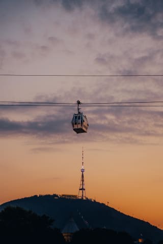 Kolejka linowa nad Tbilisi na tle Wieży Telewizyjnej o zmierzchu