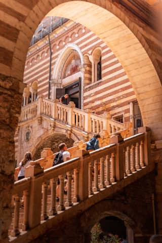 Turyści wchodzą po zachwycających, gotyckich schodach w historycznych murach Palazzo della Ragione