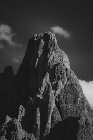 Rozświetlona iglica Dolomites nad płynącymi chmurami
