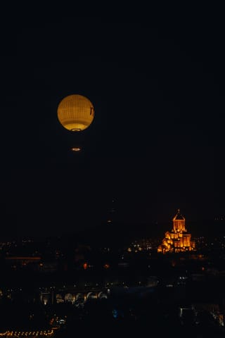 Nocna panorama Tbilisi: Balon widokowy i Sobór Trójcy Świętej