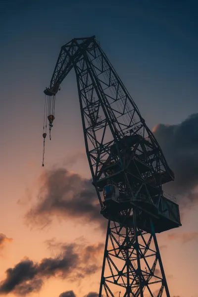 Silhouette of a Shipyard Crane at Dusk