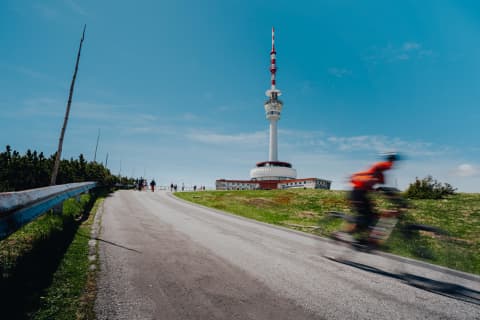 Cyclist Racing Past The Pradziad Summit Tower