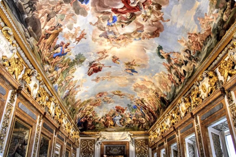 Ceiling fresco depicting various figures and scenes, richly adorned with gold detailing and ornate woodwork.