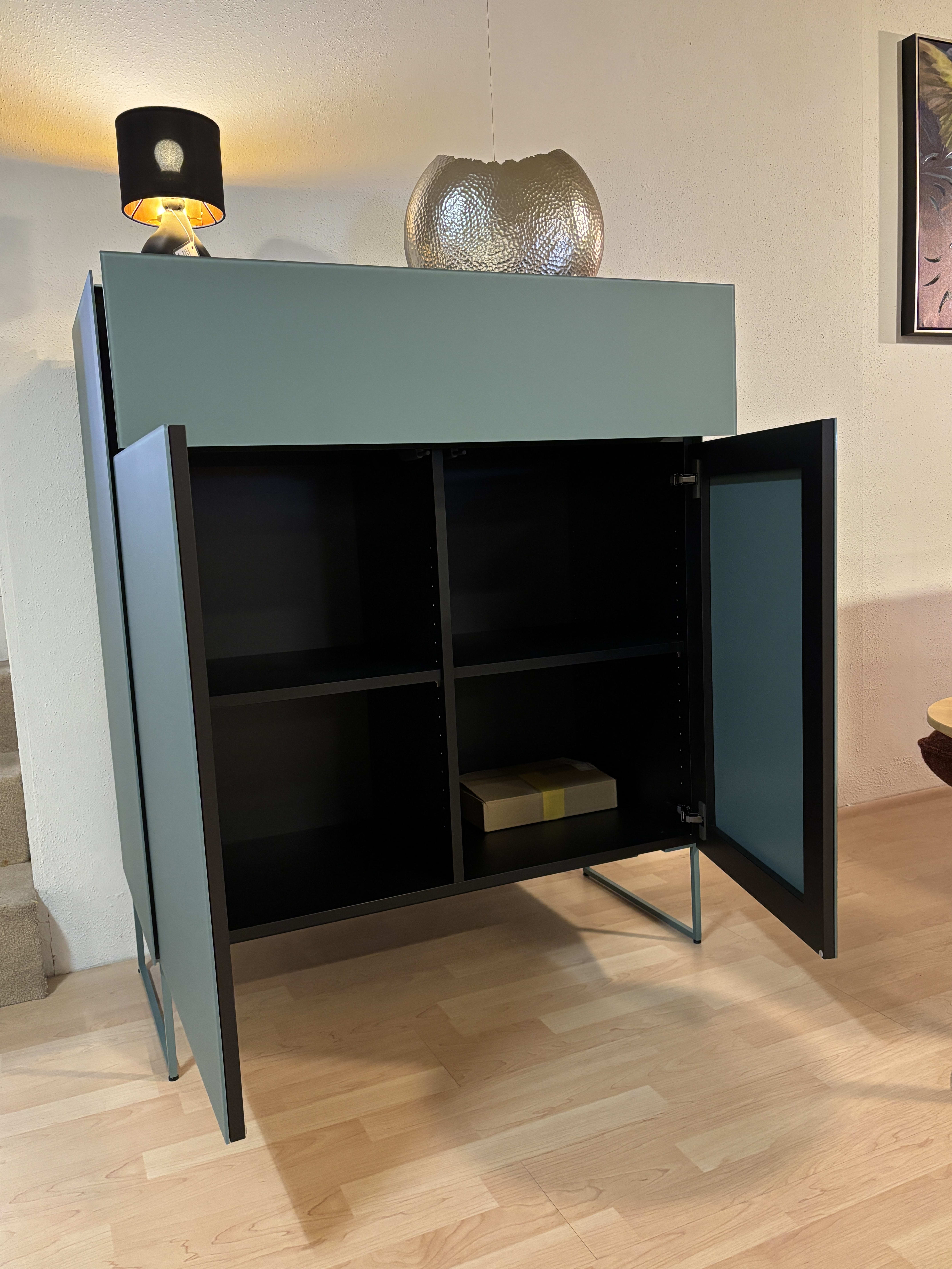 Das Spectral Sideboard 101cm ist ein tealfarbener Schrank mit offenen Türen, Einlegeböden und einer Box im Inneren, die mit einer Lampe und einer Glasschale gekrönt wird.