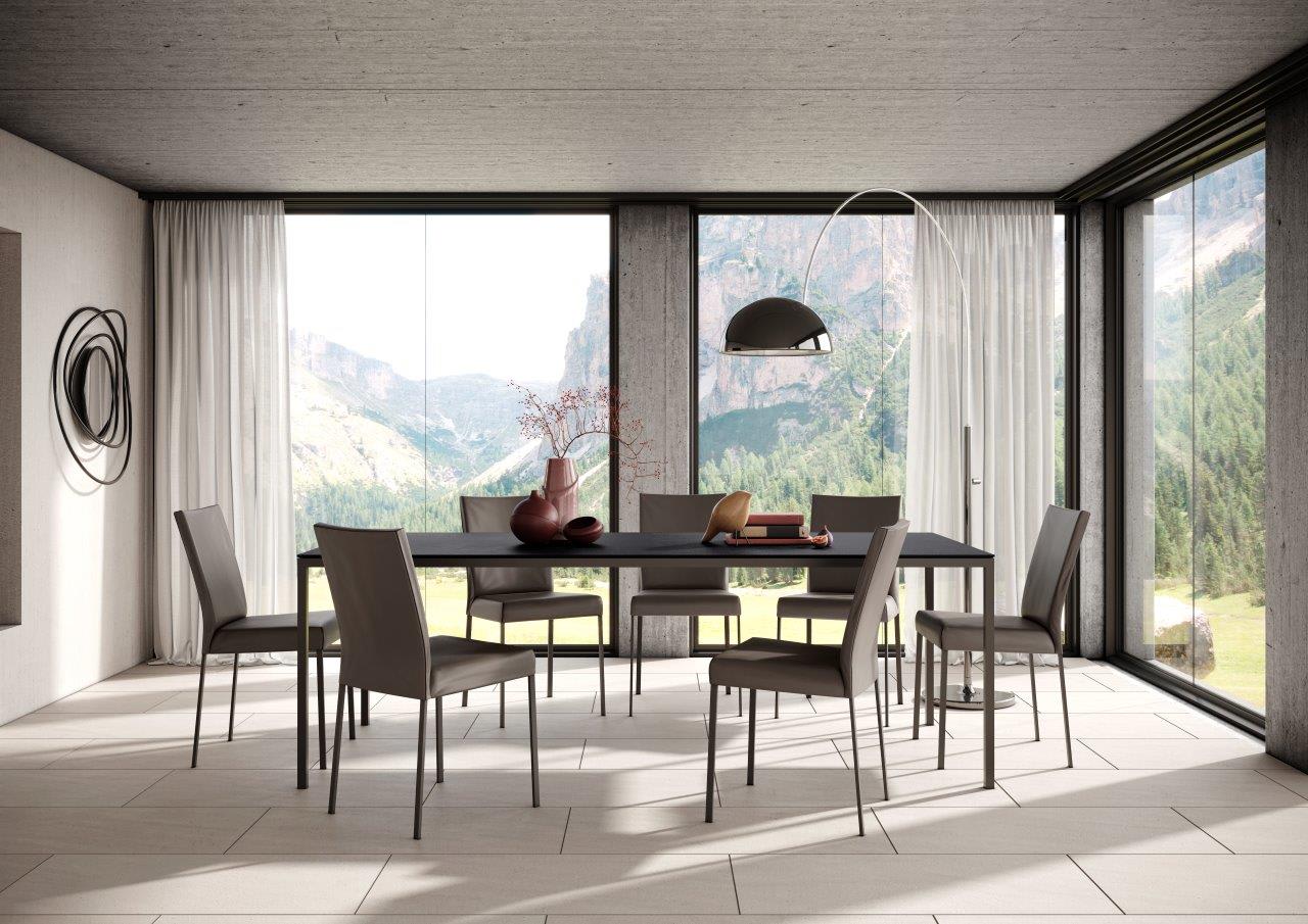 Modernes Esszimmer mit großen Fenstern, Blick auf die Berge, minimalistischem Willisau Esstisch Dino, sechs Stühlen und zeitgenössischem Dekor. Modernes Esszimmer mit großen Fenstern, Blick auf die Berge, minimalistischem Willisau Esstisch Dino, sechs Stühlen und zeitgenössischem Dekor.