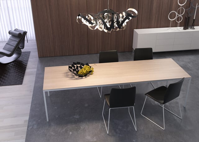 Modernes Esszimmer mit dem Willisau Esstisch Dino aus Holz, vier schwarzen Stühlen und einer Schale mit Obst unter einer skulpturalen Leuchte. Modernes Esszimmer mit dem Willisau Esstisch Dino aus Holz, vier schwarzen Stühlen und einer Schale mit Obst unter einer skulpturalen Leuchte.