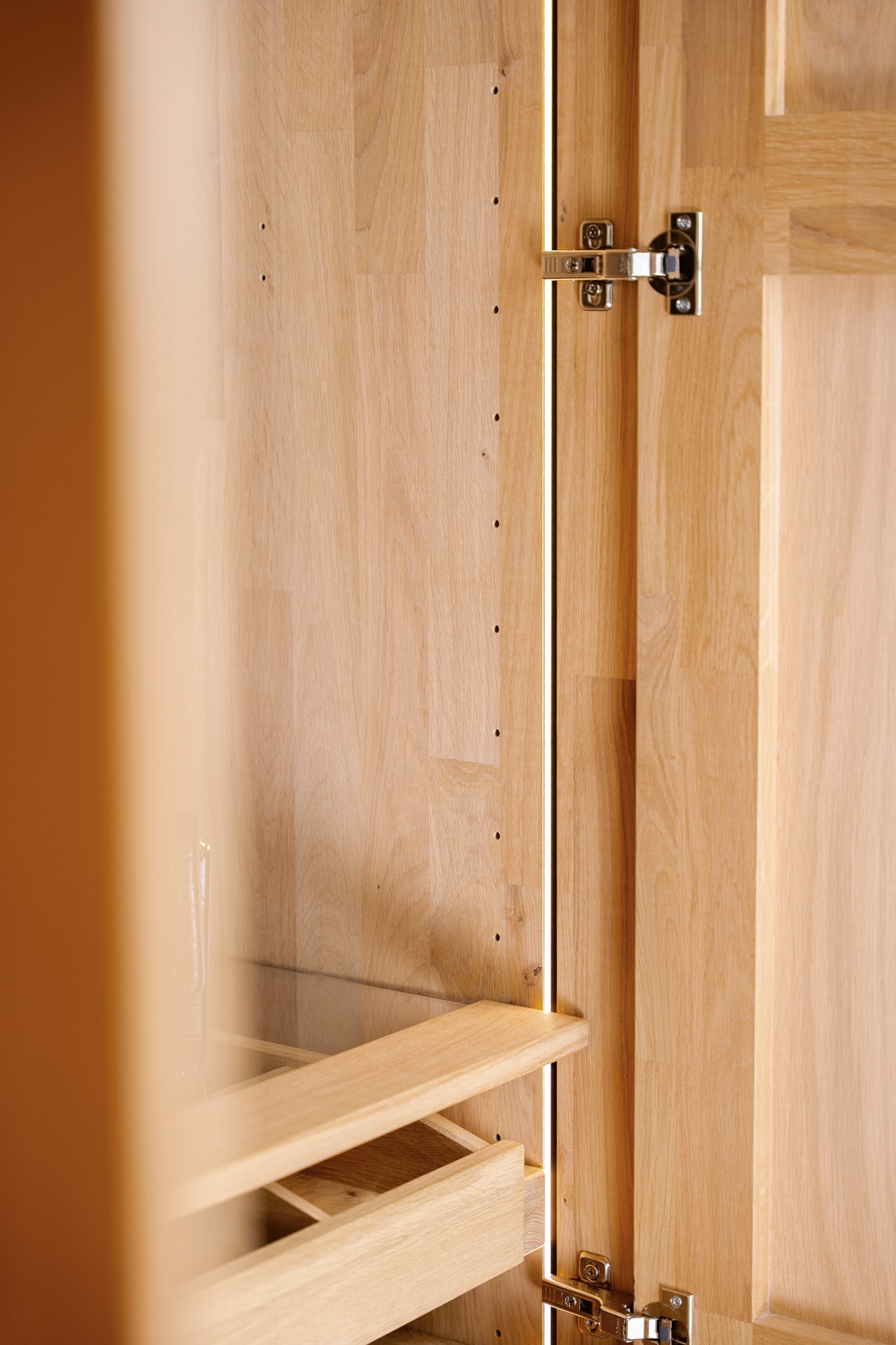 Nahaufnahme des Holzschranks des Wimmer Bett Silvan mit offenen Türen und sichtbaren Scharnieren. Nahaufnahme des Holzschranks des Wimmer Bett Silvan mit offenen Türen und sichtbaren Scharnieren.