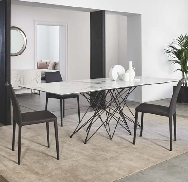 Modernes Esszimmer mit einem Marmortisch, schwarzen Bonaldo Stuhl Kayla Stühlen, Keramikdekor und einer Topfpflanze auf einem beigen Teppich. Modernes Esszimmer mit einem Marmortisch, schwarzen Bonaldo Stuhl Kayla Stühlen, Keramikdekor und einer Topfpflanze auf einem beigen Teppich.