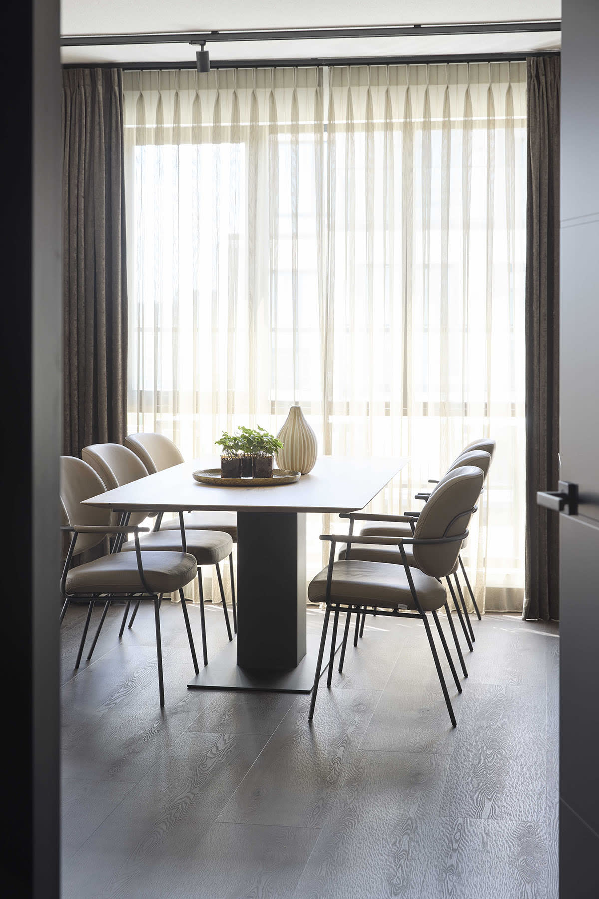 Minimalistisches Esszimmer mit einem rechteckigen Tisch, sechs Stühlen von bert plantagie Stuhl Blake Schlitten und transparenten Vorhängen, die den Raum mit natürlichem Licht erfüllen. Minimalistisches Esszimmer mit einem rechteckigen Tisch, sechs Stühlen von bert plantagie Stuhl Blake Schlitten und transparenten Vorhängen, die den Raum mit natürlichem Licht erfüllen.