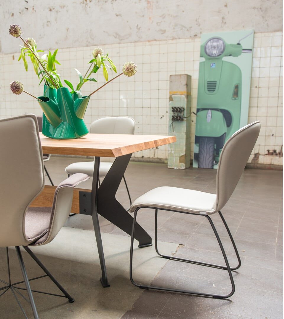 Moderner Essbereich mit beigen Stühlen von bert plantagie Stuhl Blake Schlitten, einem Holztisch, einer grünen Vase mit Blumen und grüner Roller-Wandmalerei. Moderner Essbereich mit beigen Stühlen von bert plantagie Stuhl Blake Schlitten, einem Holztisch, einer grünen Vase mit Blumen und grüner Roller-Wandmalerei.