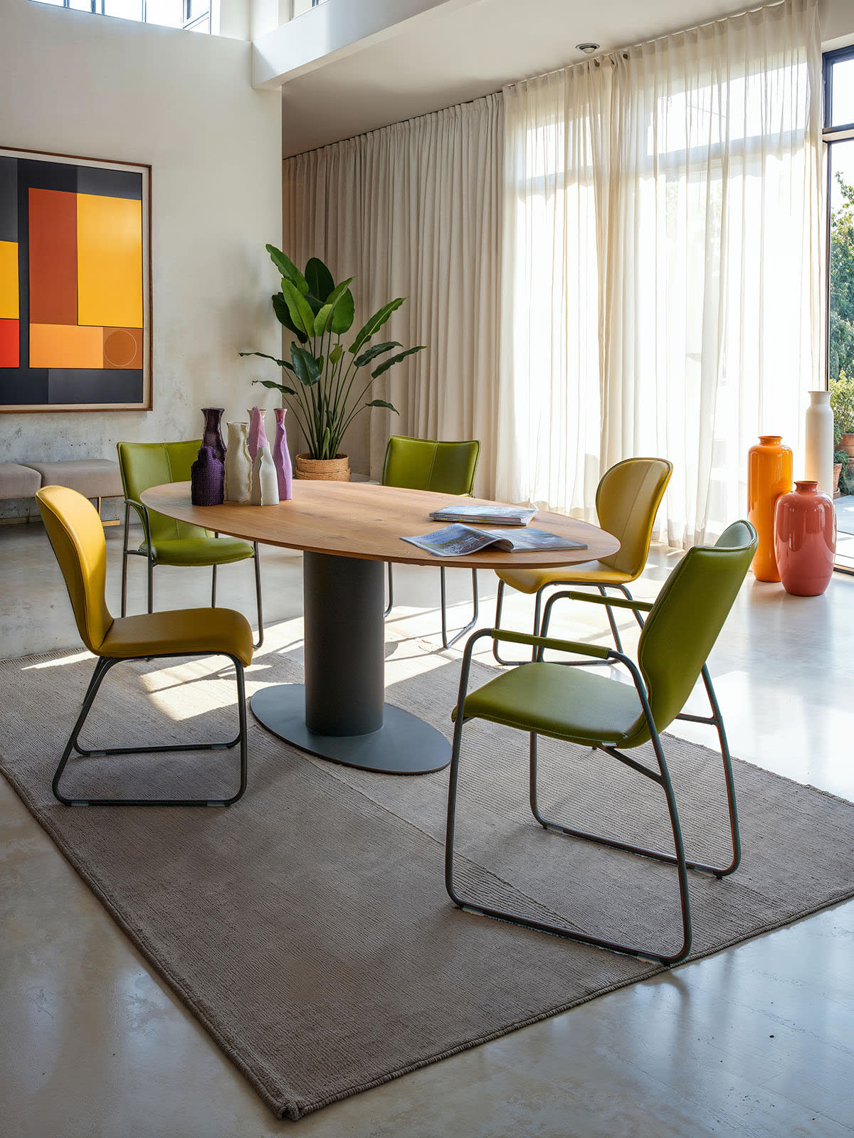 Modernes Esszimmer mit Holztisch, bert plantagie Stuhl Blake Schlitten grüne Stühle, Pflanzen, große Fenster und abstrakte Kunst an der Wand. Modernes Esszimmer mit Holztisch, bert plantagie Stuhl Blake Schlitten grüne Stühle, Pflanzen, große Fenster und abstrakte Kunst an der Wand.