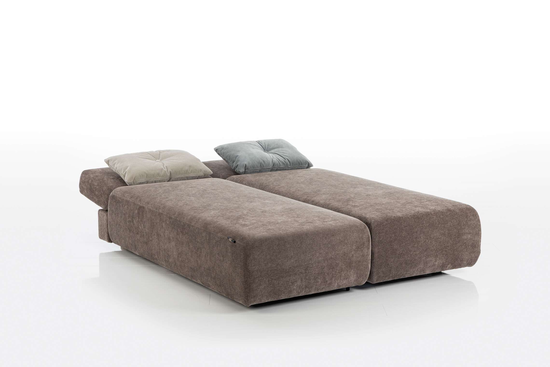 Das Brühl Funktionssofa Piano Small, ein braun gepolstertes Schlafsofa, wird flach aufgeklappt, mit zwei Kissen darauf und vor einem weißen Hintergrund. Das Brühl Funktionssofa Piano Small, ein braun gepolstertes Schlafsofa, wird flach aufgeklappt, mit zwei Kissen darauf und vor einem weißen Hintergrund.