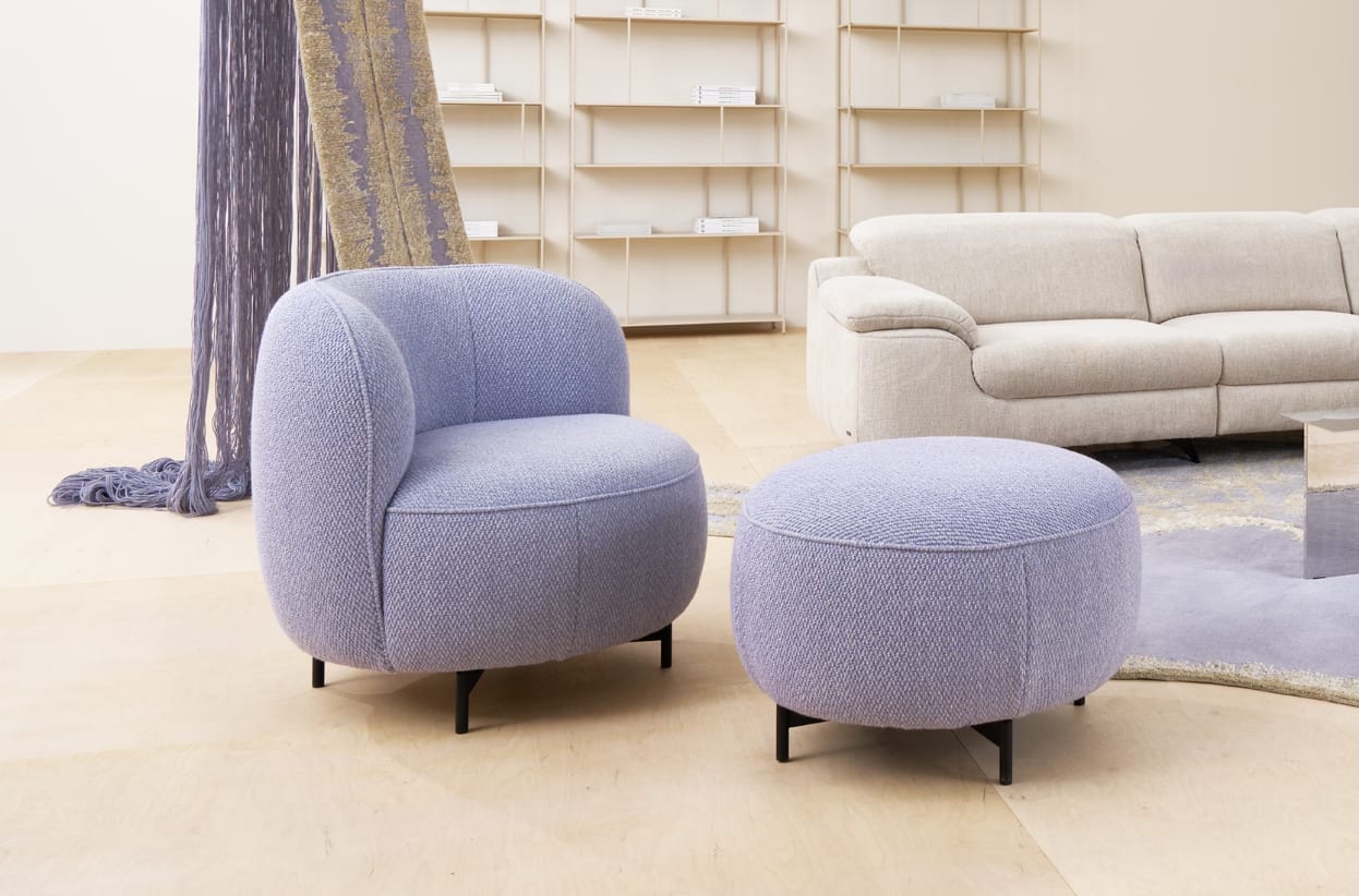Der Himolla Einzelsessel 7596 mit Ottomane steht auf einem hellen Holzboden, gepaart mit einem beigen Sofa und Regalen in einem modernen Wohnzimmer. Der Himolla Einzelsessel 7596 mit Ottomane steht auf einem hellen Holzboden, gepaart mit einem beigen Sofa und Regalen in einem modernen Wohnzimmer.