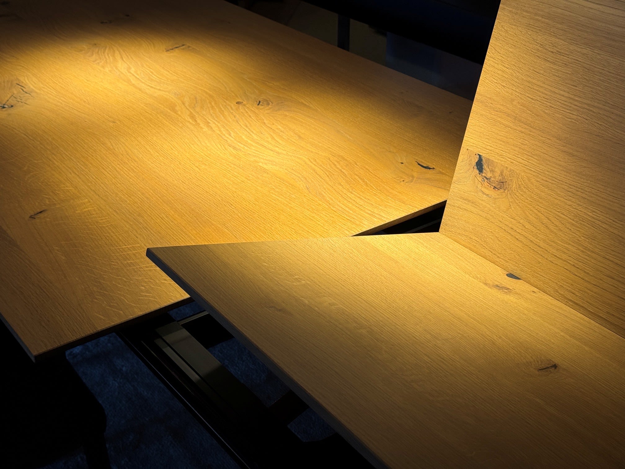 Das Sonnenlicht beleuchtet die natürliche Maserung und die dunklen Äste der schrägen Holzbretter des Girsberger Auszugstisches Bela und setzt warme Akzente. Das Sonnenlicht beleuchtet die natürliche Maserung und die dunklen Äste der schrägen Holzbretter des Girsberger Auszugstisches Bela und setzt warme Akzente.