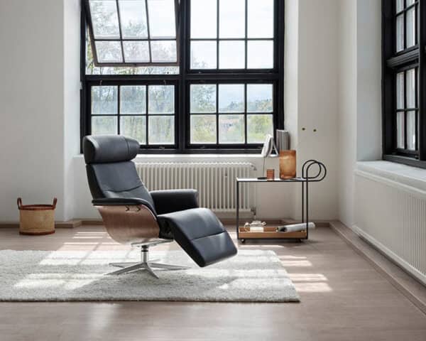 Ein minimalistischer Raum ist mit dem schwarzen Loungesessel SALE 25 Sessel Time Out, einem Beistelltisch und großen Gitterfenstern ausgestattet. Licht strömt herein und erhellt den Raum. Ein minimalistischer Raum ist mit dem schwarzen Loungesessel SALE 25 Sessel Time Out, einem Beistelltisch und großen Gitterfenstern ausgestattet. Licht strömt herein und erhellt den Raum.