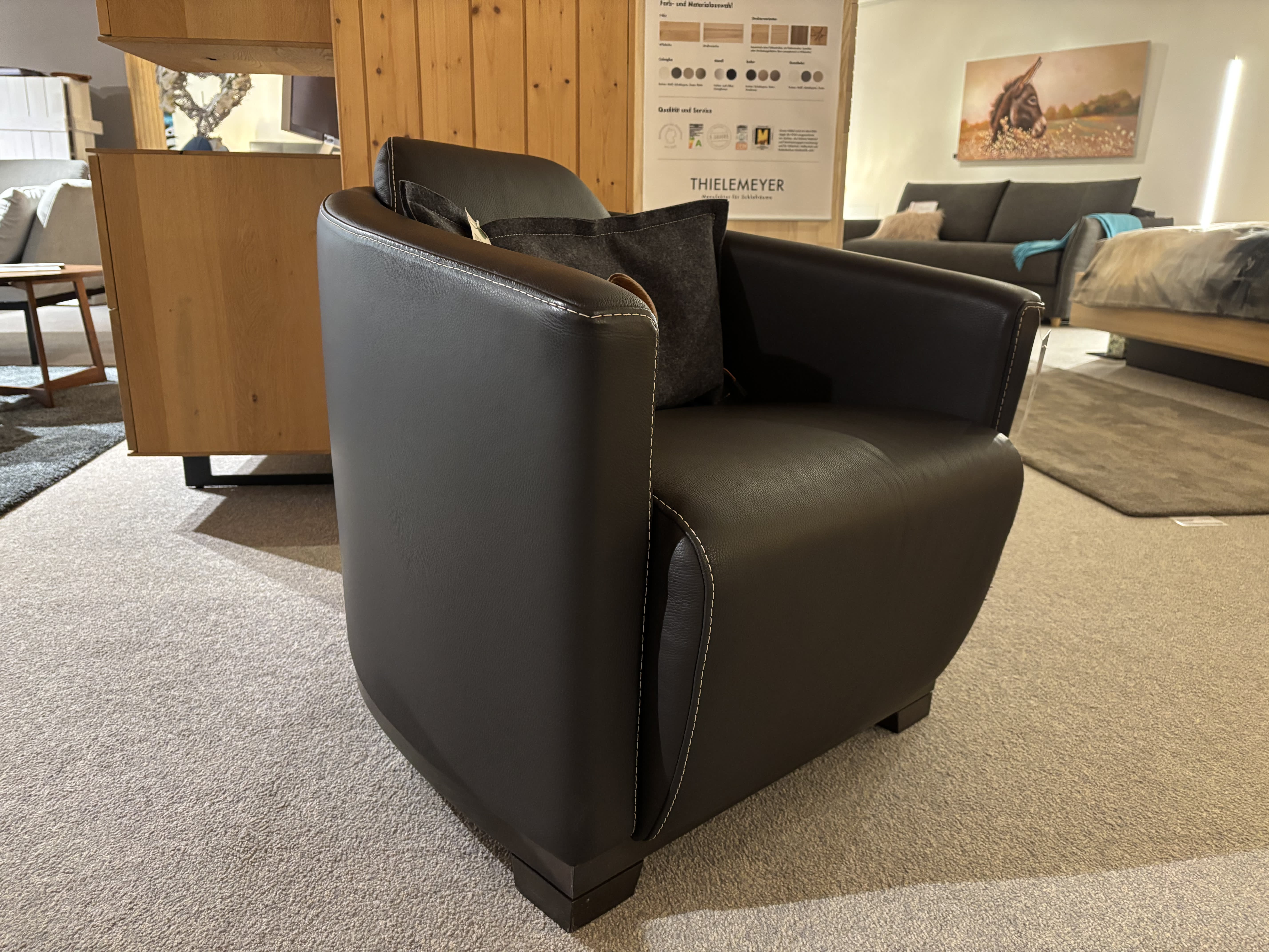 Ein Büromöbel mit 3 Boxen Window in schwarzer Lederausführung mit weißen Nähten, in einem modernen Wohnzimmer. Ein Büromöbel mit 3 Boxen Window in schwarzer Lederausführung mit weißen Nähten, in einem modernen Wohnzimmer.