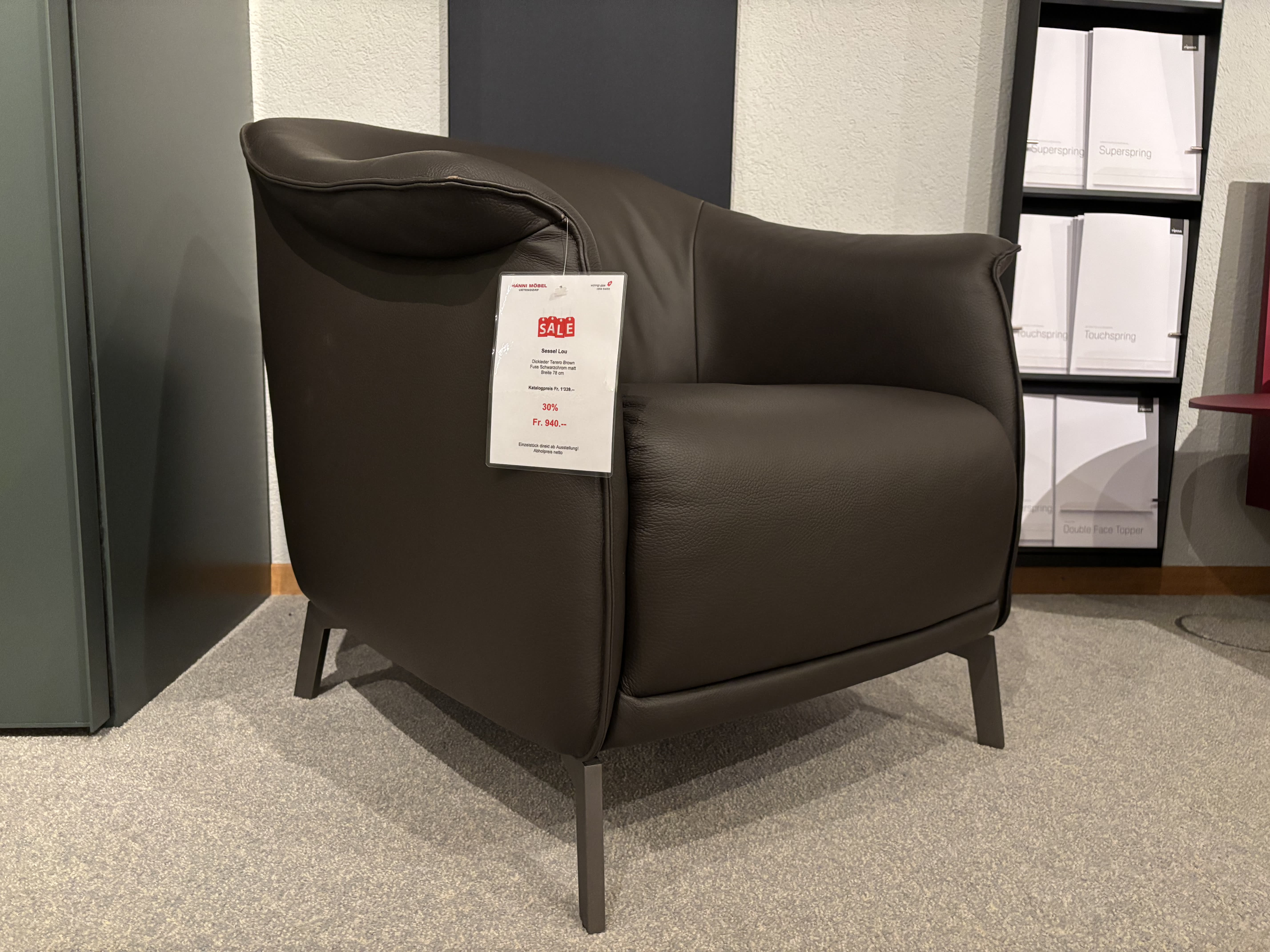 Ein Büromöbel mit 3 Boxenfenstern in Dunkelgrau mit einem Verkaufsschild, präsentiert in einem Ausstellungsraum. Ein Büromöbel mit 3 Boxenfenstern in Dunkelgrau mit einem Verkaufsschild, präsentiert in einem Ausstellungsraum.