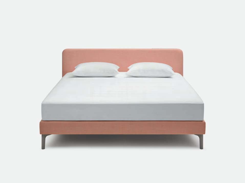 Das Riposa Boxspringbett Slow ist ein modernes Bett mit einem rosa gepolsterten Kopf- und Unterteil, ergänzt durch zwei weiße Kissen und eine makellos weiße Matratze. Das Riposa Boxspringbett Slow ist ein modernes Bett mit einem rosa gepolsterten Kopf- und Unterteil, ergänzt durch zwei weiße Kissen und eine makellos weiße Matratze.