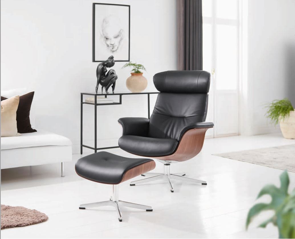 Ein Sessel Time Out mit Hocker in modernem Schwarz wird in einem hellen, minimalistischen Wohnzimmer aufgestellt. Ein Sessel Time Out mit Hocker in modernem Schwarz wird in einem hellen, minimalistischen Wohnzimmer aufgestellt.