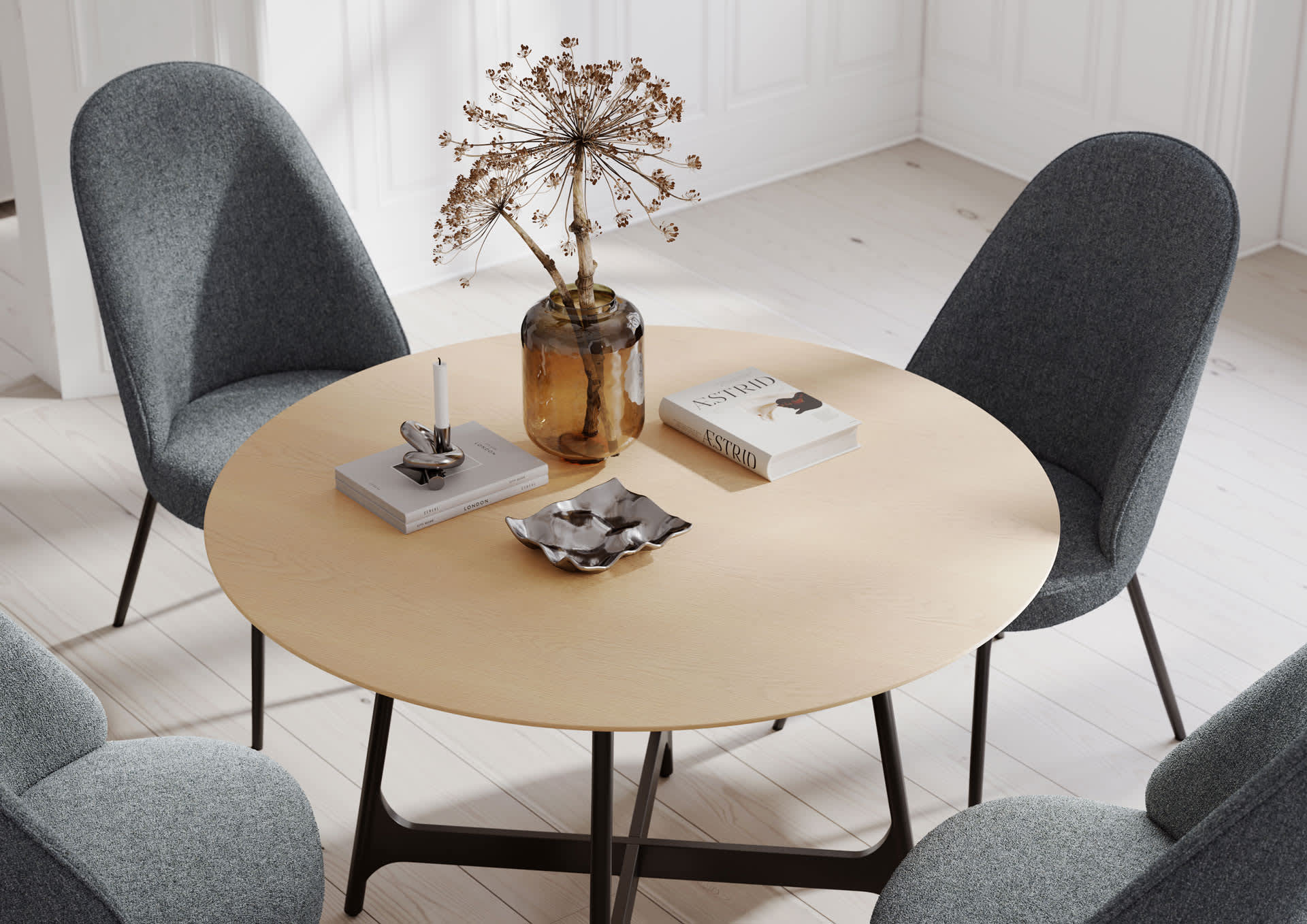 Der Dan Form Tisch Ooid ist ein runder Holztisch mit vier grauen Stühlen, auf dem eine Vase mit Trockenblumen, Büchern und einer Kerze steht. Der Dan Form Tisch Ooid ist ein runder Holztisch mit vier grauen Stühlen, auf dem eine Vase mit Trockenblumen, Büchern und einer Kerze steht.