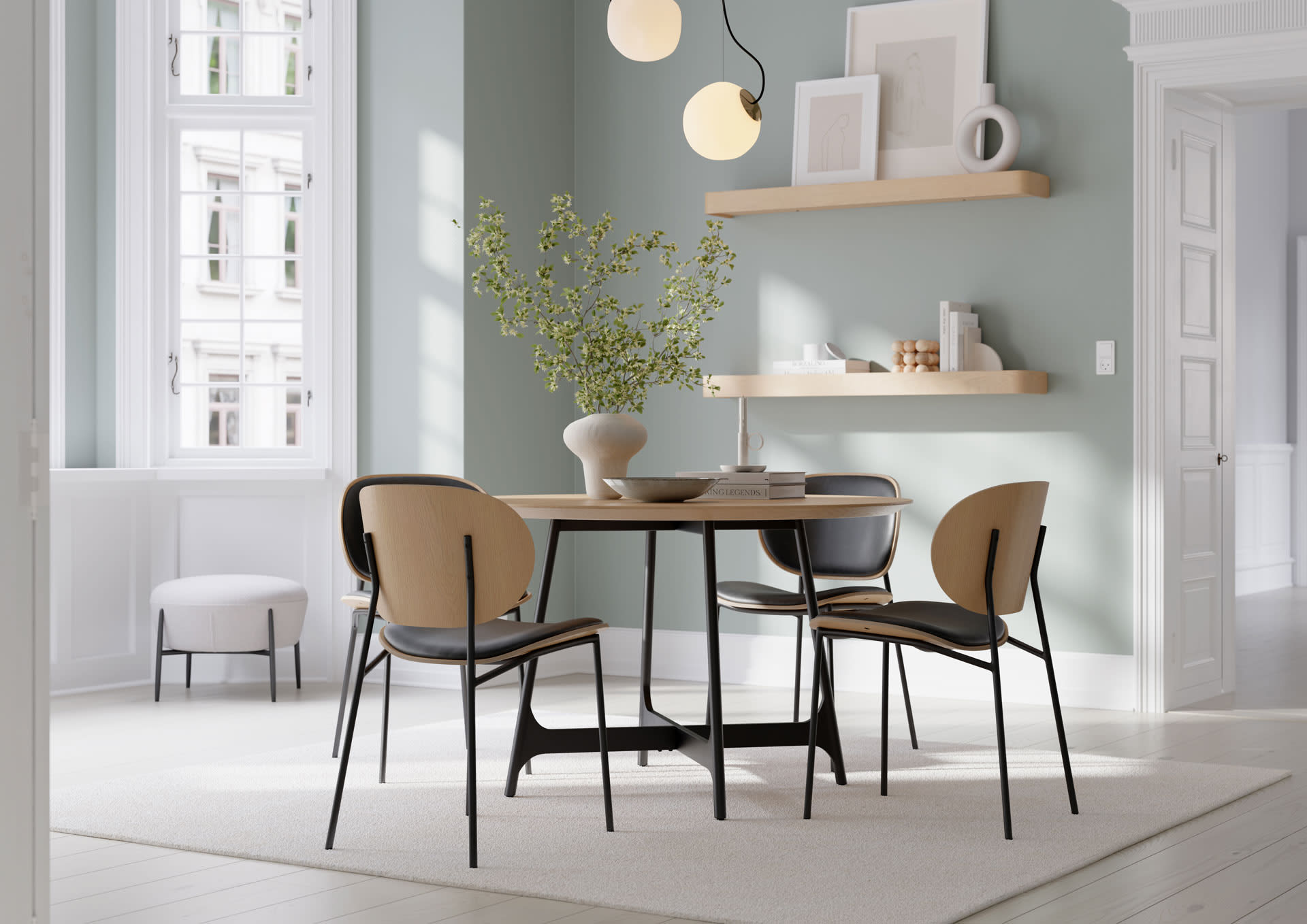 Salle à manger moderne avec une table ronde Dan Form Ooid, quatre chaises, des murs verts, des étagères et un vase avec des branches. Salle à manger moderne avec une table ronde Dan Form Ooid, quatre chaises, des murs verts, des étagères et un vase avec des branches.