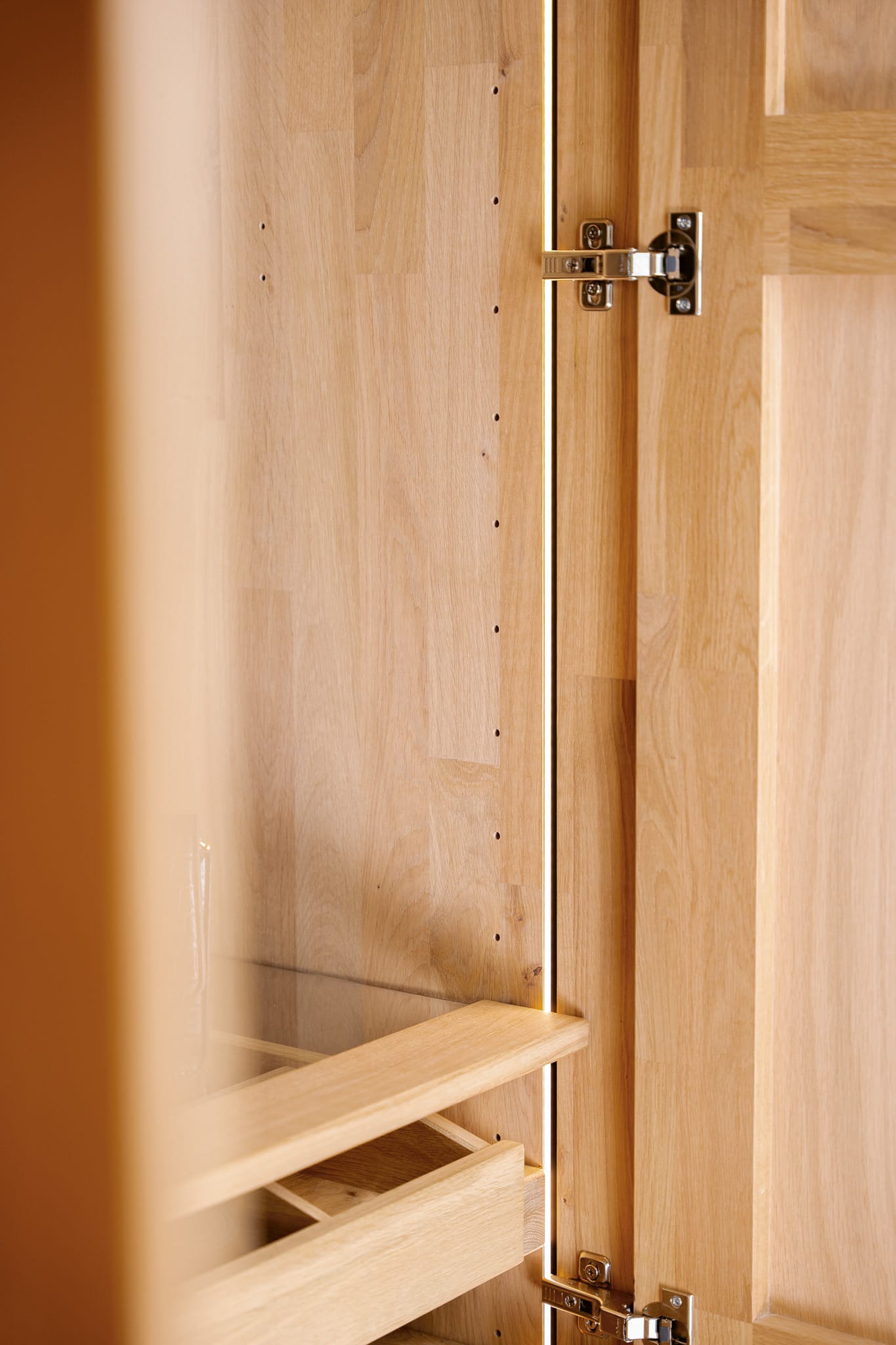 Gros plan sur le meuble en bois du lit Wimmer Silvan, portes ouvertes et charnières visibles. Gros plan sur le meuble en bois du lit Wimmer Silvan, portes ouvertes et charnières visibles.
