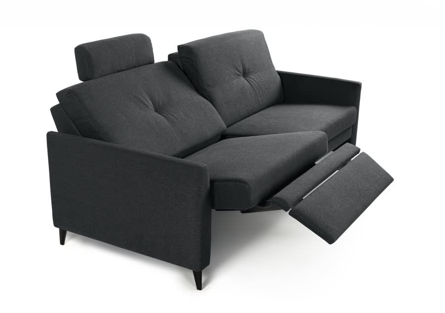 Das Horst Sofa Chiasso ist ein dunkelgraues Liegesofa mit verstellbaren Kopfstützen und verlängerten Fußstützen, das vor einem weißen Hintergrund steht. Das Horst Sofa Chiasso ist ein dunkelgraues Liegesofa mit verstellbaren Kopfstützen und verlängerten Fußstützen, das vor einem weißen Hintergrund steht.