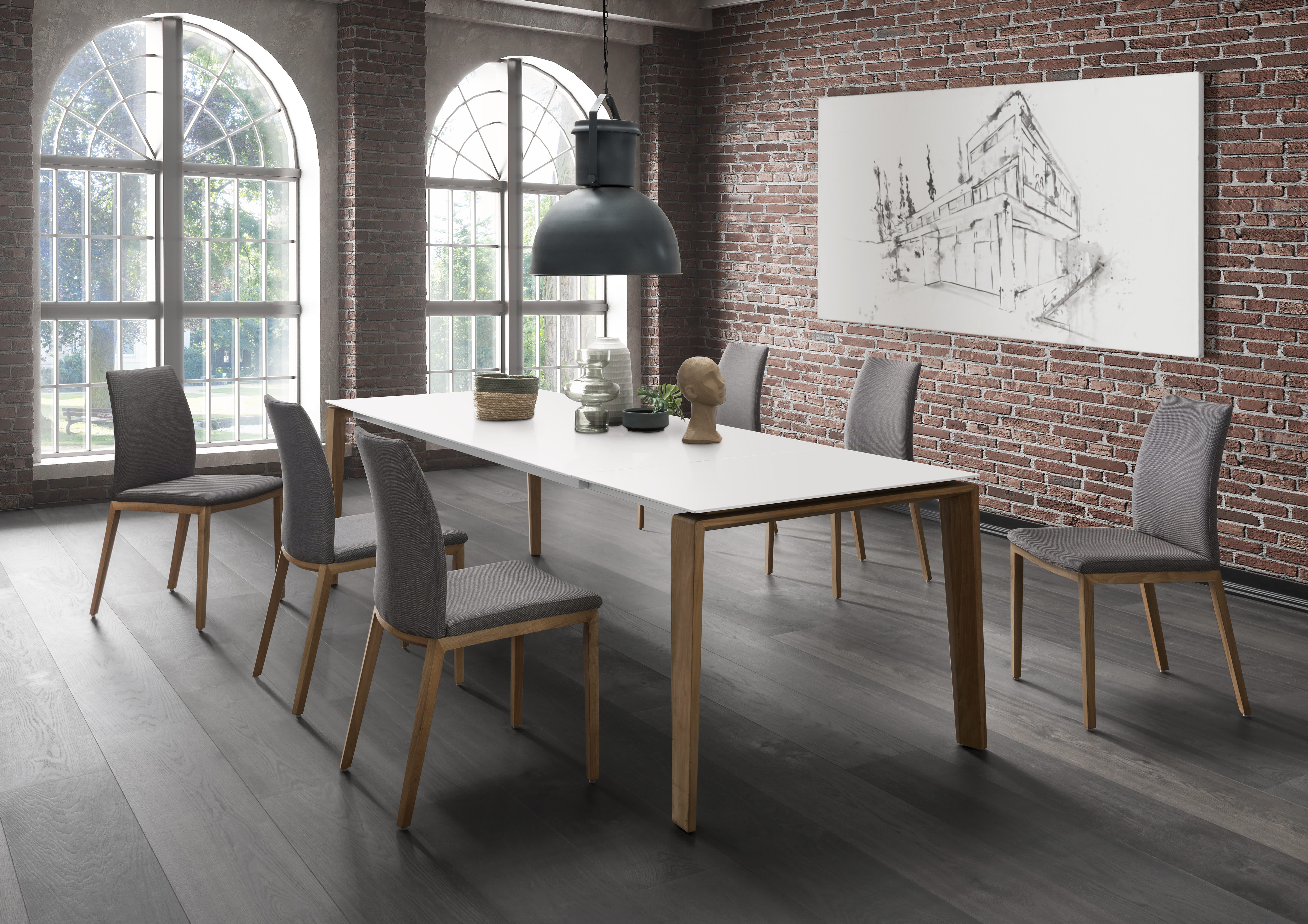 Modernes Esszimmer mit dem Sit Mobilia Tisch Olympia Turin, sechs Stühlen, Backsteinwänden, großen Fenstern und einem skizzenhaften Kunstwerk. Modernes Esszimmer mit dem Sit Mobilia Tisch Olympia Turin, sechs Stühlen, Backsteinwänden, großen Fenstern und einem skizzenhaften Kunstwerk.