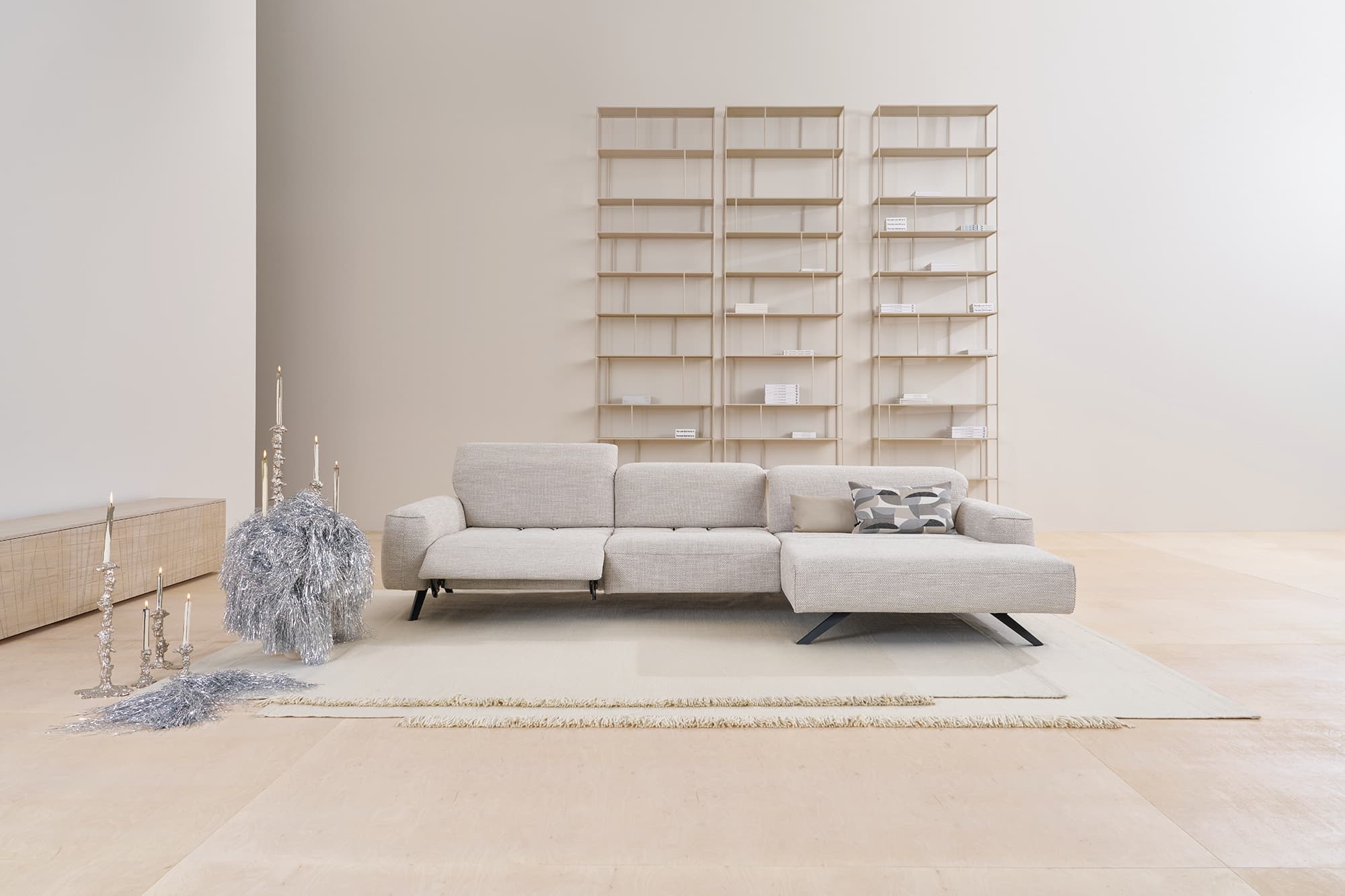 Modernes minimalistisches Wohnzimmer mit dem Himolla Sofa Signa 1552 in Hellgrau, ergänzt durch Regale und minimale dekorative Akzente. Modernes minimalistisches Wohnzimmer mit dem Himolla Sofa Signa 1552 in Hellgrau, ergänzt durch Regale und minimale dekorative Akzente.