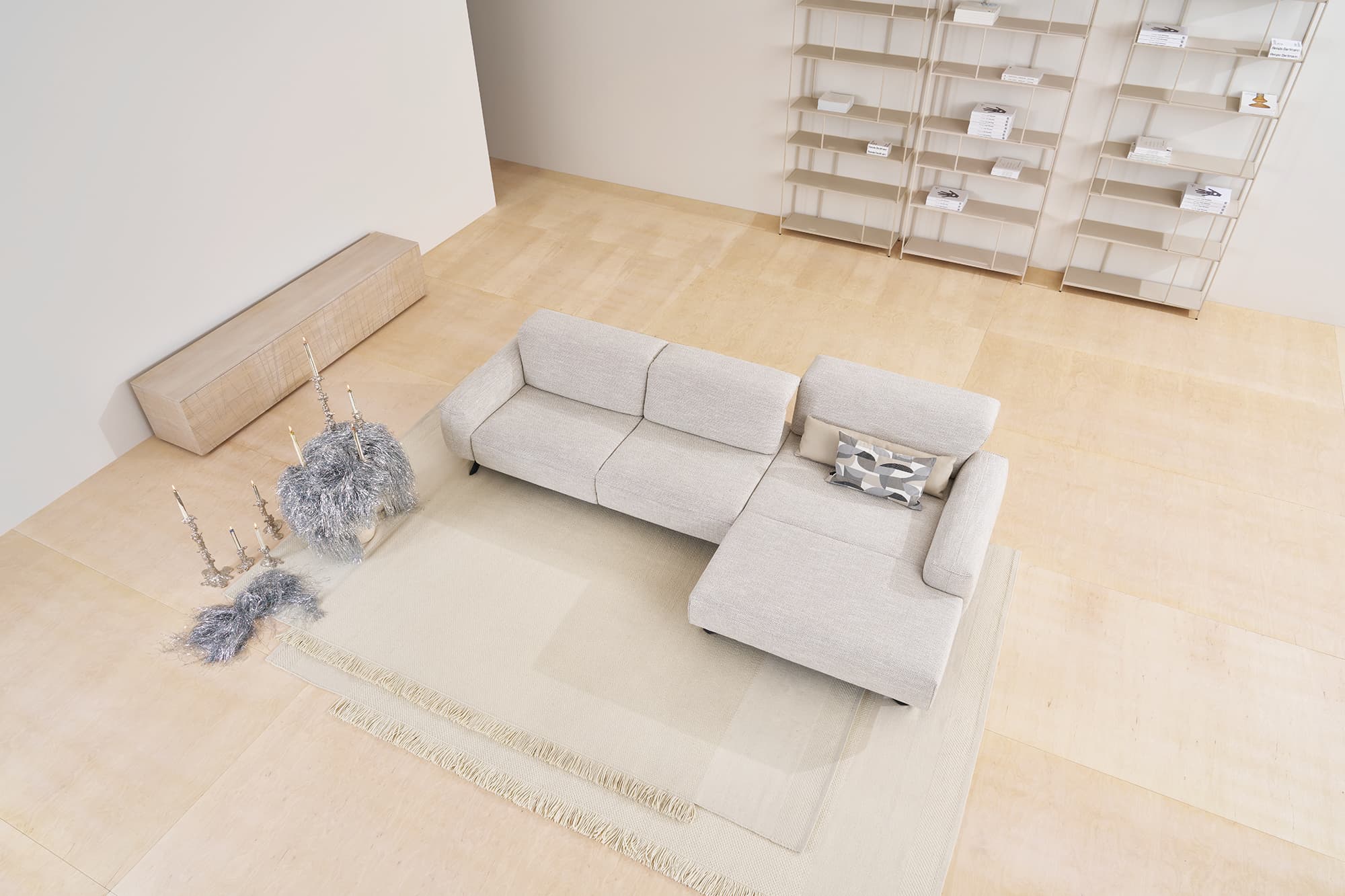 Modernes Wohnzimmer mit dem Himolla Sofa Signa 1552 in Hellgrau, gepaart mit Teppichen, minimalem Dekor und leeren Regalen. Modernes Wohnzimmer mit dem Himolla Sofa Signa 1552 in Hellgrau, gepaart mit Teppichen, minimalem Dekor und leeren Regalen.