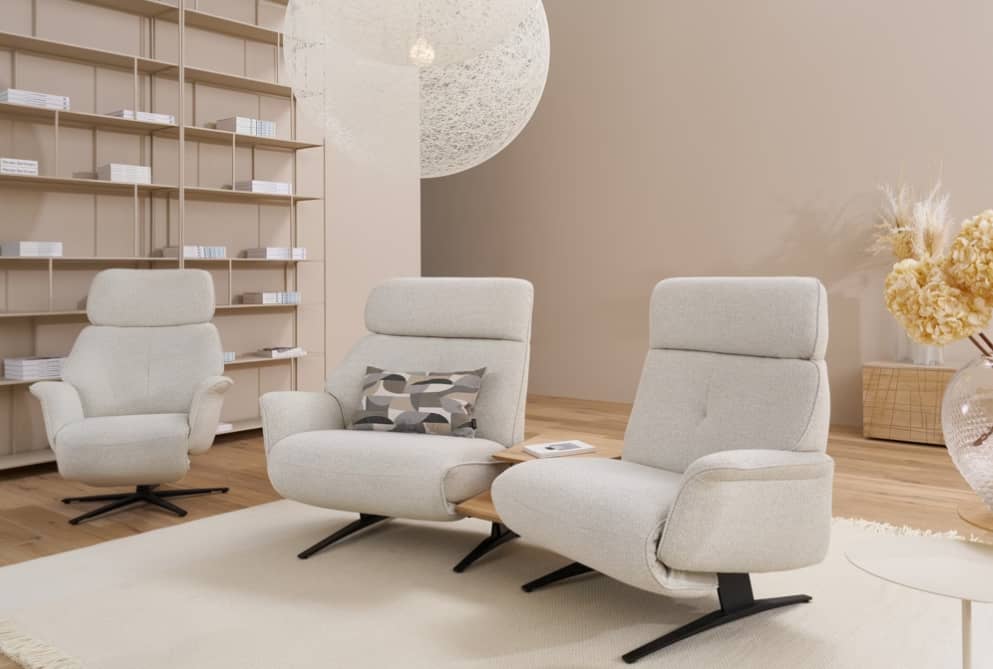 Modernes Wohnzimmer mit drei Himolla Trapezsofa 4362 Lounges, einem eingebauten Bücherregal und einer dekorativen Pendelleuchte. Modernes Wohnzimmer mit drei Himolla Trapezsofa 4362 Lounges, einem eingebauten Bücherregal und einer dekorativen Pendelleuchte.