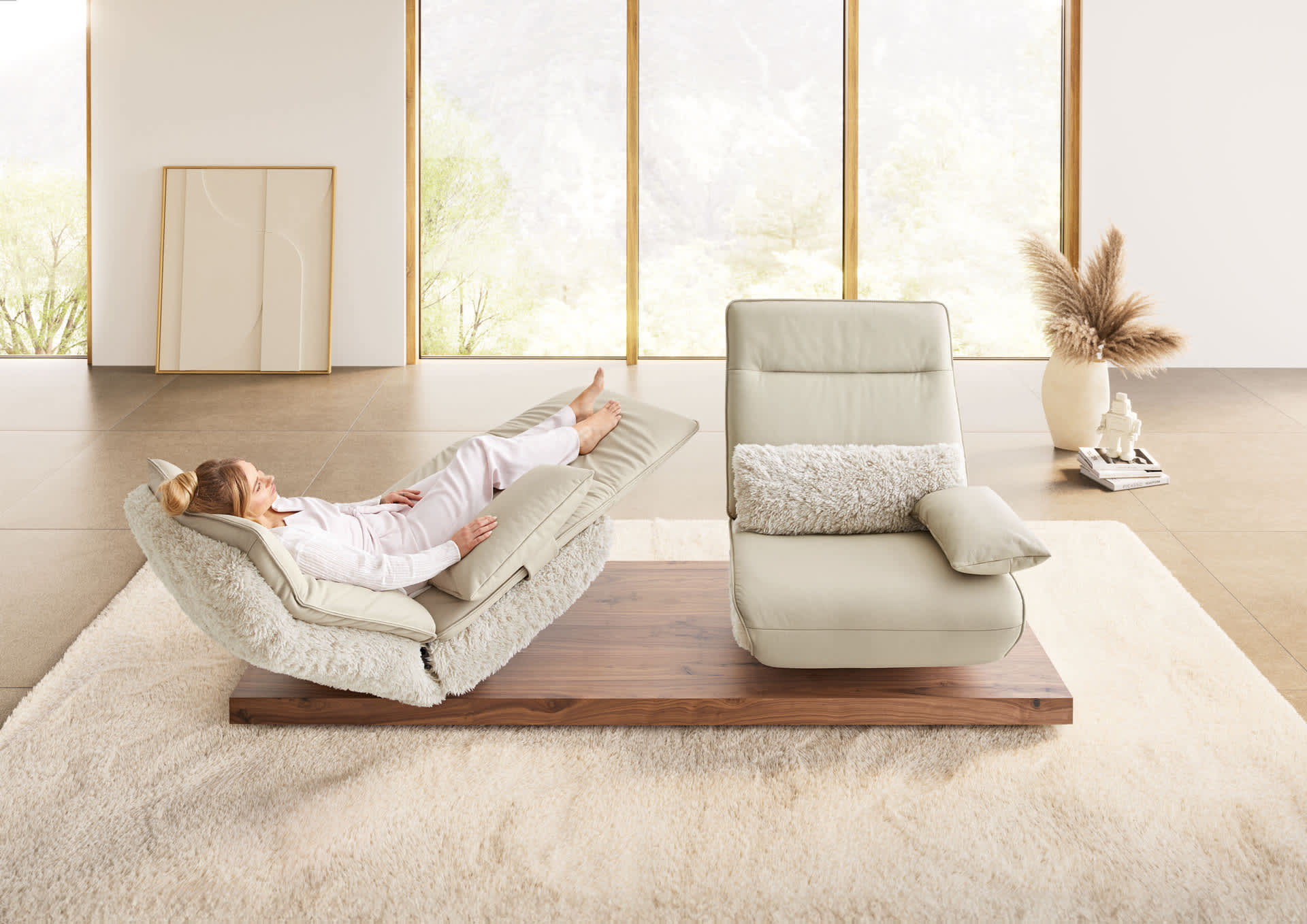 Une personne se détend sur le canapé fonctionnel Koinor Evino, un fauteuil de repos réglable et doux, dans une pièce lumineuse avec de grandes fenêtres et une décoration minimaliste. Une personne se détend sur le canapé fonctionnel Koinor Evino, un fauteuil de repos réglable et doux, dans une pièce lumineuse avec de grandes fenêtres et une décoration minimaliste.