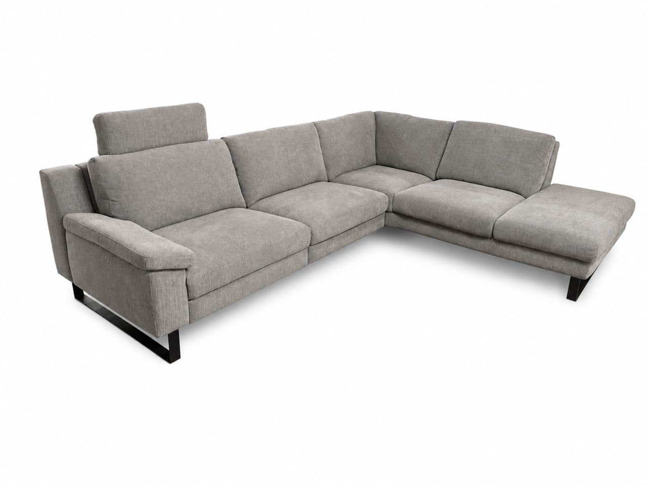 Die DFM-Polstergruppe „Casablanca“ ist ein graues L-förmiges Modulsofa mit Metallfüßen, breiten Armlehnen und einer verstellbaren Kopfstütze an einem Sitzplatz. Die DFM-Polstergruppe „Casablanca“ ist ein graues L-förmiges Modulsofa mit Metallfüßen, breiten Armlehnen und einer verstellbaren Kopfstütze an einem Sitzplatz.