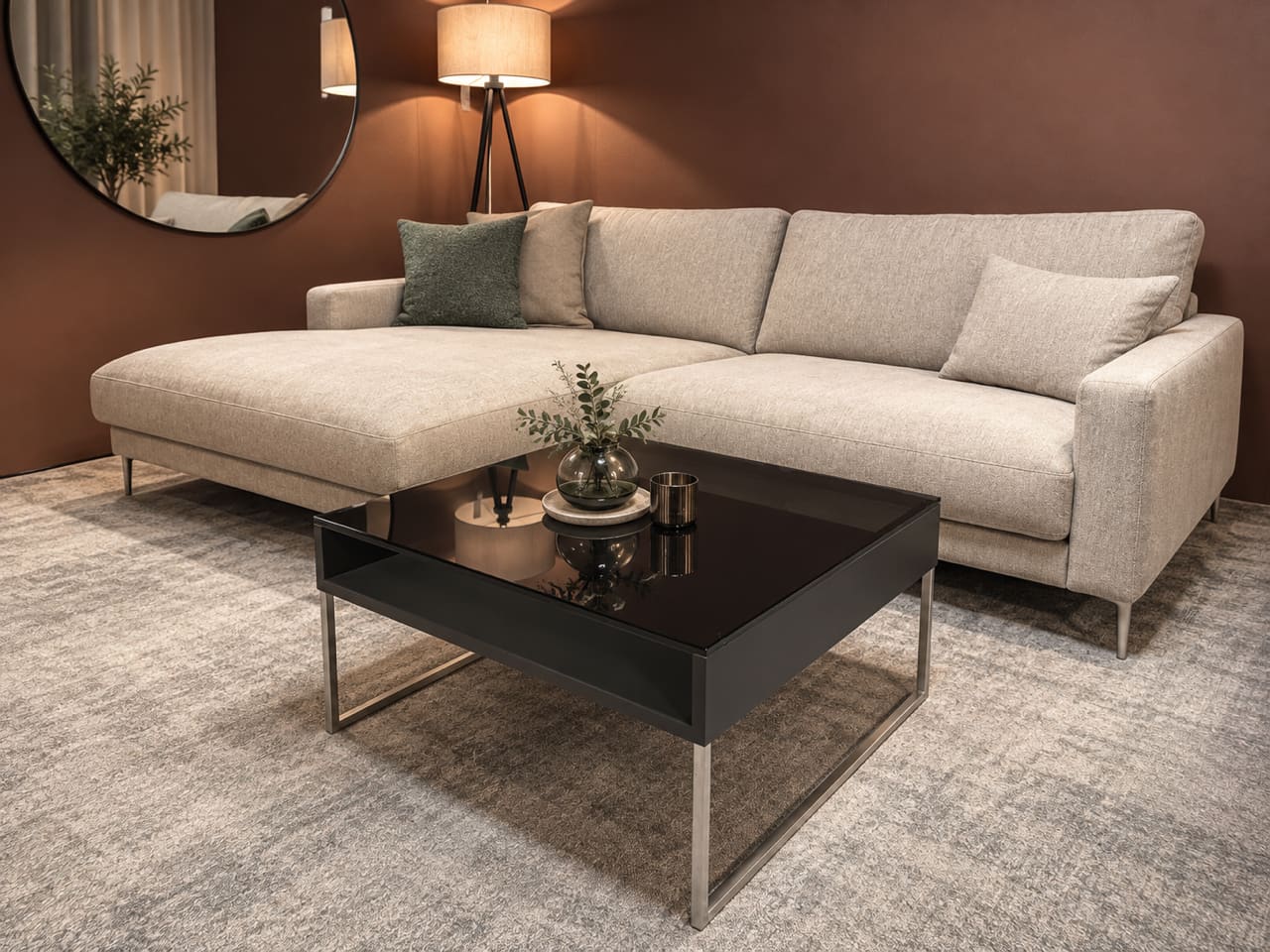 Modernes Wohnzimmer mit einem beigen Ecksofa, dem „Spectral Couchtisch“ als Couchtisch, einer Stehlampe und einem Dekospiegel. Modernes Wohnzimmer mit einem beigen Ecksofa, dem „Spectral Couchtisch“ als Couchtisch, einer Stehlampe und einem Dekospiegel.