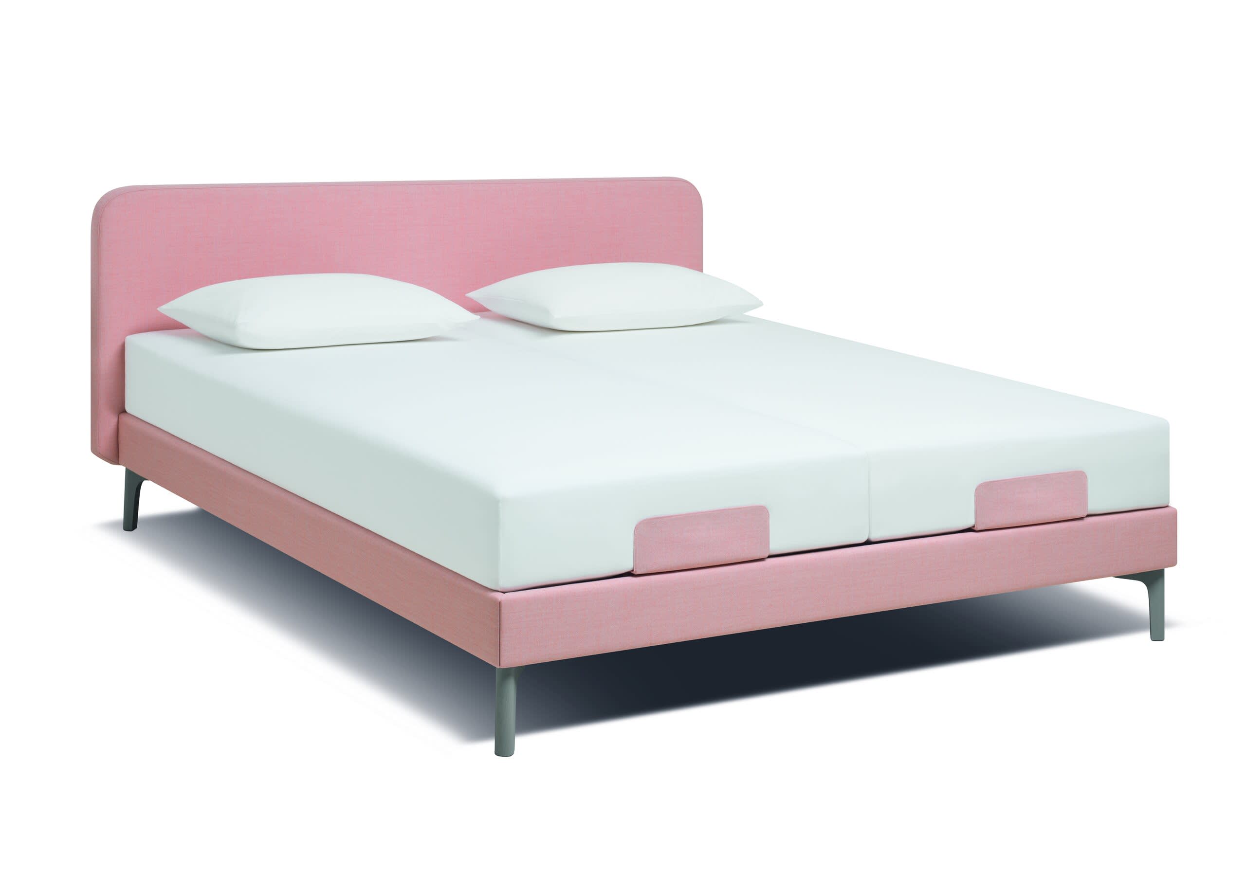 Das Riposa Boxspringbett Slow ist ein rosa gepolstertes Doppelbett mit zwei weißen Kissen und weißen Matratzen auf weißem Hintergrund.