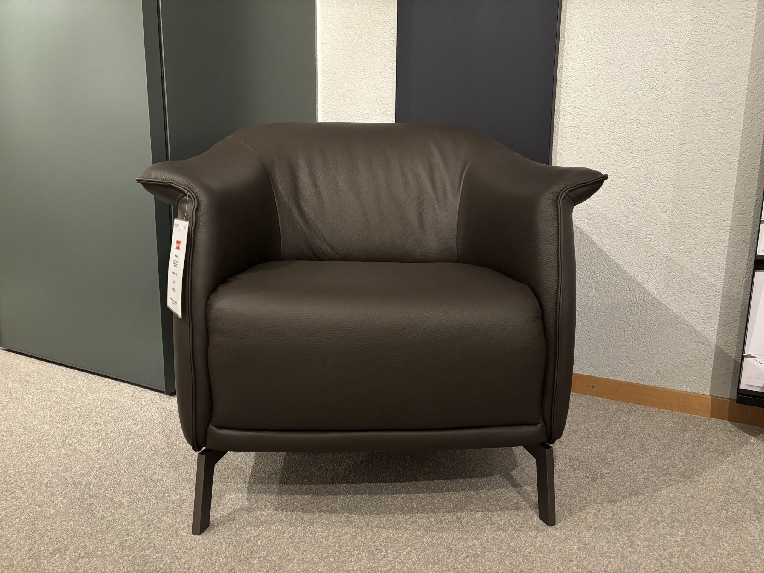 Büromöbel mit 3 Boxen Window, ein dunkler Ledersessel mit stabilen Beinen, ausgestellt in einem Ausstellungsraum. Büromöbel mit 3 Boxen Window, ein dunkler Ledersessel mit stabilen Beinen, ausgestellt in einem Ausstellungsraum.