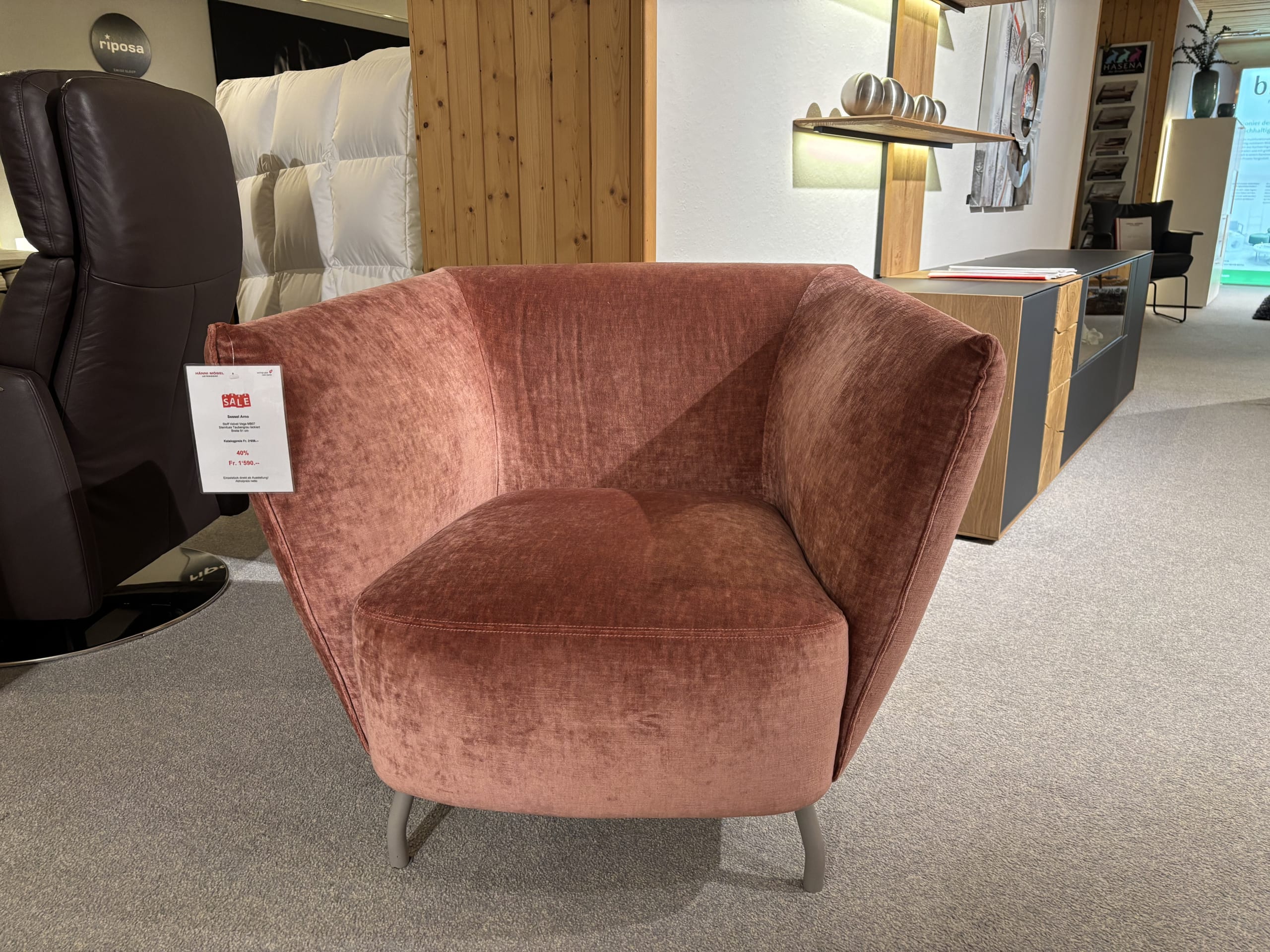 Un fauteuil de bureau à 3 fenêtres avec revêtement rose et côtés inclinés exposé dans une salle d&#39;exposition moderne.