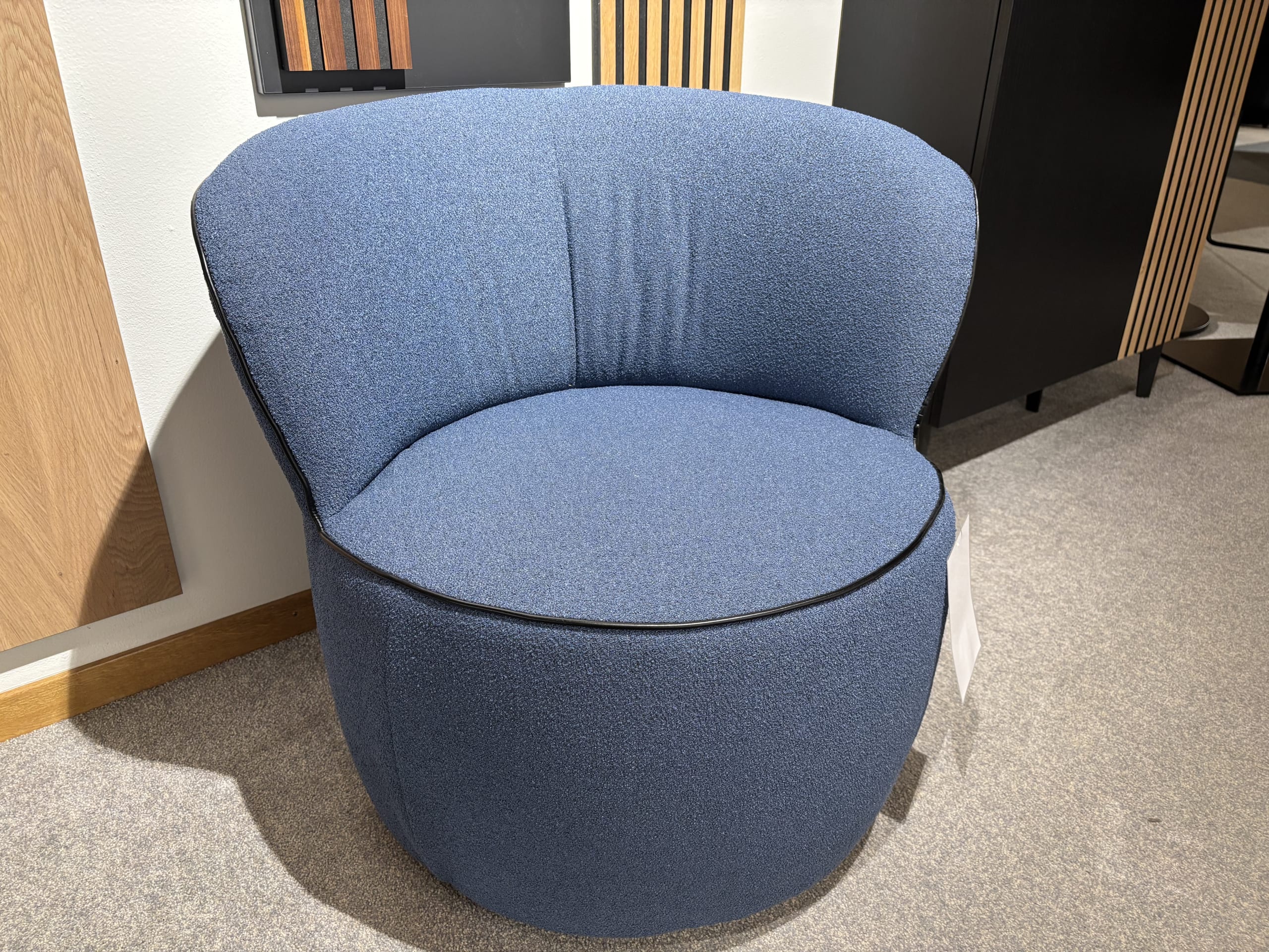 Ein moderner, blau gepolsterter Stuhl mit abgerundeter Rückenlehne, Teil der Büromöbel mit 3 Boxen Window-Kollektion, steht auf einem Teppichboden. Ein moderner, blau gepolsterter Stuhl mit abgerundeter Rückenlehne, Teil der Büromöbel mit 3 Boxen Window-Kollektion, steht auf einem Teppichboden.