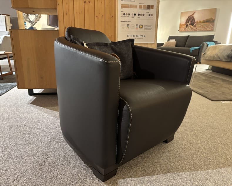 Ein Büromöbel mit 3 Boxen Window in schwarzer Lederausführung mit weißen Nähten, in einem modernen Wohnzimmer.