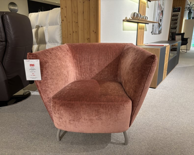 Ein Büromöbel mit 3 Boxen Window-Sessel mit rosa Polsterung und abgewinkelten Seiten, ausgestellt in einem modernen Ausstellungsraum.