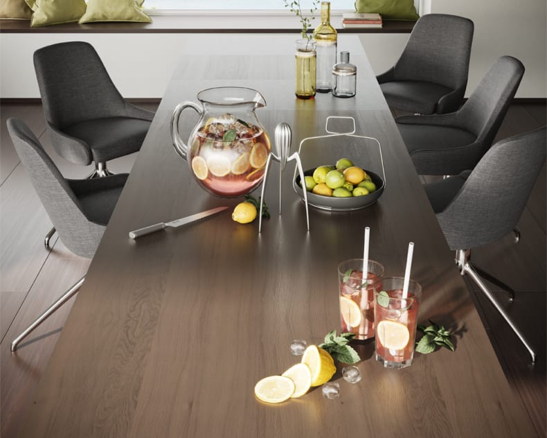 La table à manger du Willisau Prato se trouve dans une salle moderne aux chaises sombres, où sont proposés du punch aux fruits, des agrumes tranchés, des verres et un bol de citrons verts.