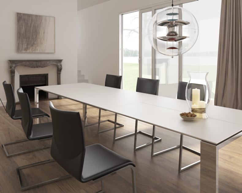 Salle à manger moderne avec chaises noires de Willisau Stuhl Vinci, une table blanche, une grande fenêtre, une cheminée et une suspension lumineuse.