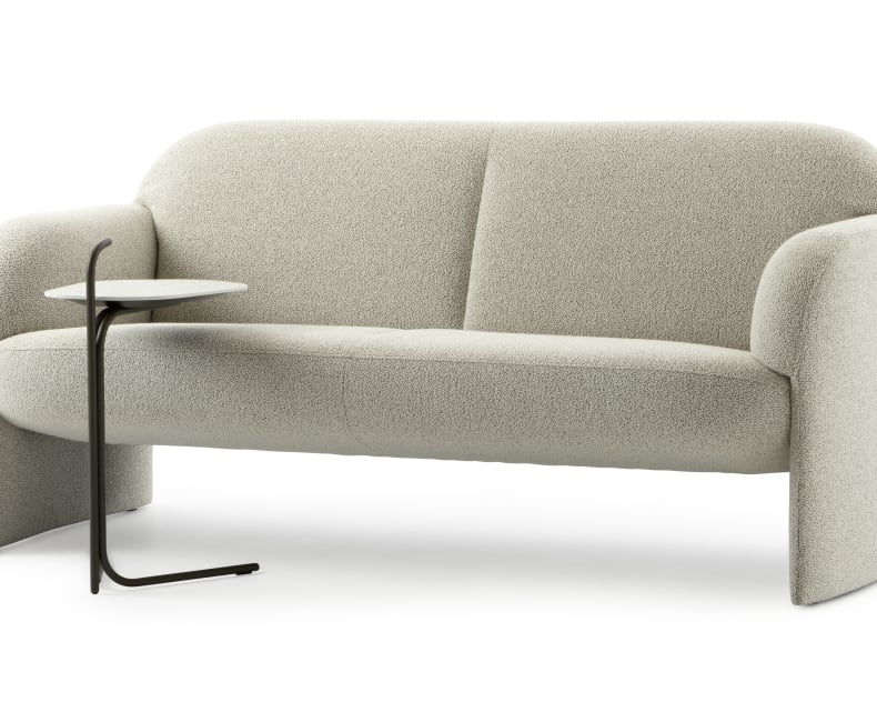 Leolux Sofa Modius in modernem Hellgrau mit abgerundeten Kanten, gepaart mit einem minimalistischen kleinen schwarzen Beistelltisch.