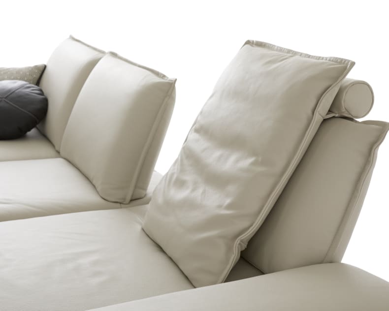 Nahaufnahme des W.Schillig Sofa Caipirinjaa 16568, ein modernes hellbeiges Sofa mit Plüschkissen und zwei Zierkissen, isoliert auf weißem Hintergrund.