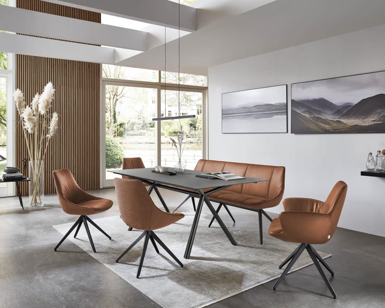 Modernes Esszimmer mit braunen Stühlen von bert plantagie Stuhl Blake Schlitten, einem schwarzen Tisch, großen Fenstern und Wandmalereien im Landschaftsstil.