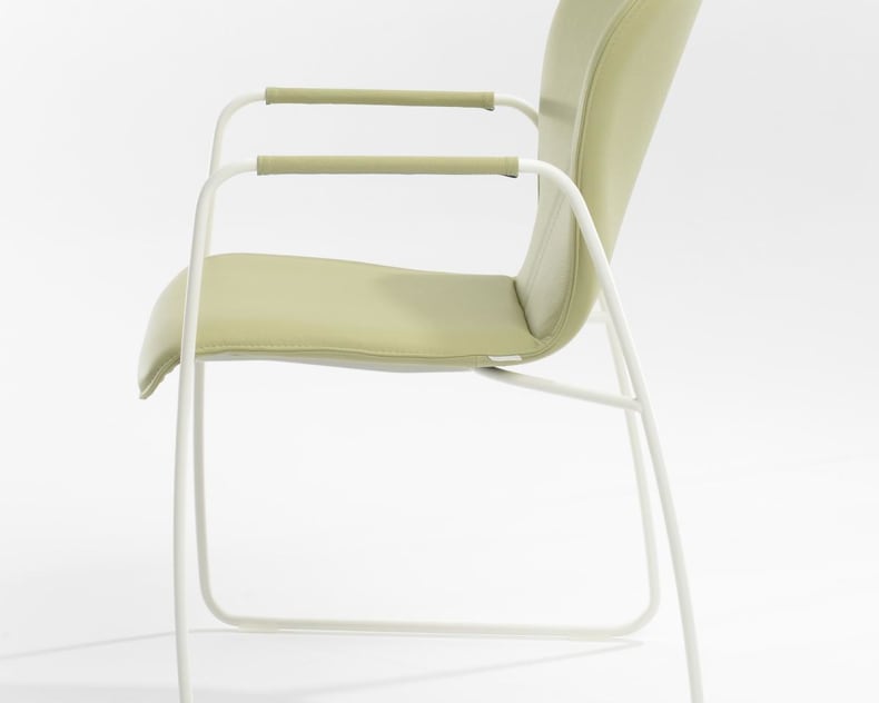 Seitenansicht des bert plantagie Stuhl Blake Schlitten, ein moderner hellgrüner Stuhl mit weißem Metallgestell und gepolstertem Sitz, Rücken und Armlehnen.