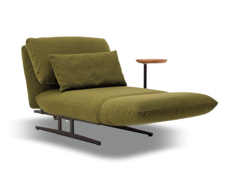 Der Signet Sessel Messina ist ein olivgrüner Loungesessel mit einem Kissen und einem kleinen runden Beistelltisch aus Holz an der rechten Armlehne.