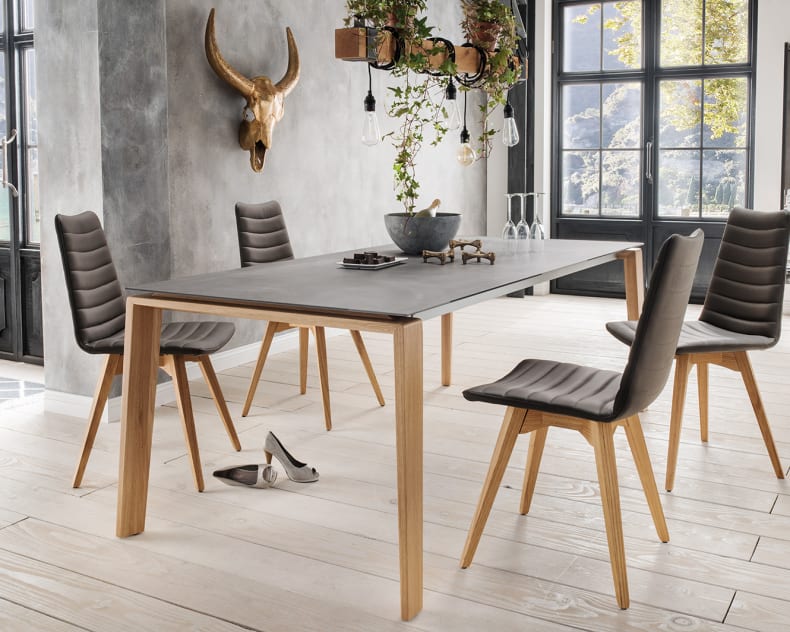 Modernes Esszimmer mit dem grauen Sit Mobilia Tisch Olympia Turin, vier Stühlen, Hängepflanzen und Schuhen auf einem hellen Holzboden.